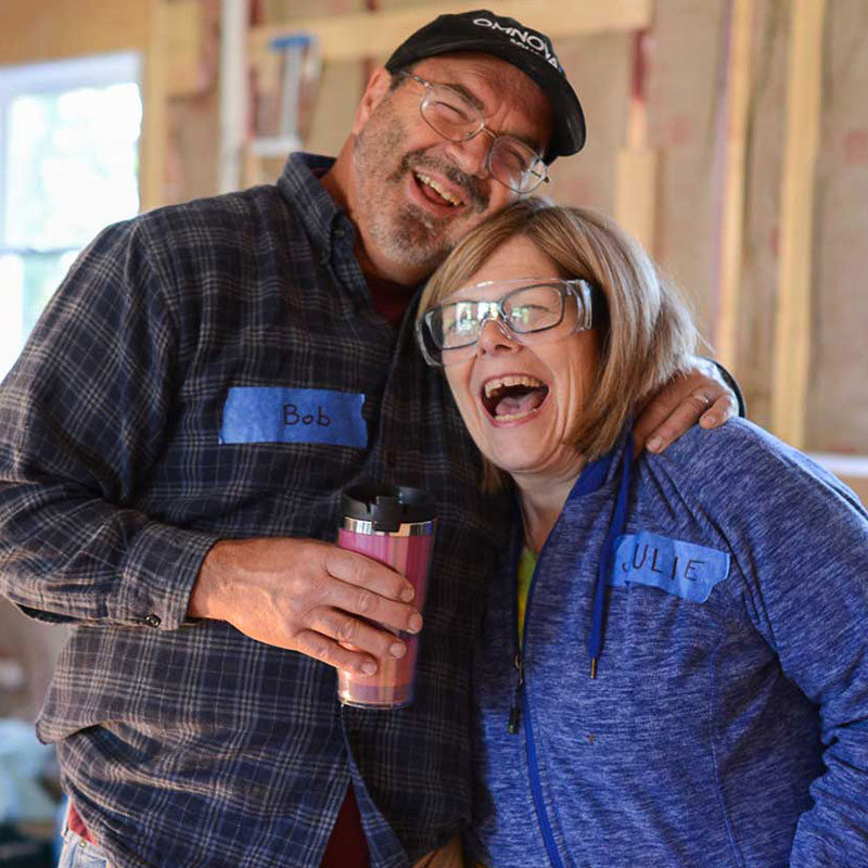 two people smiling in house under construction